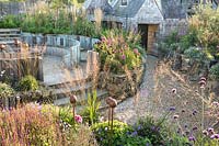 Large Pub garden with autumn border and raised beds with Olive tree showing the pub in the back ground, Jo Thompson garden Design, Ticehurst, East Sussex 