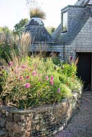 View across pub garden with late summer border and stone wall bed, Jo Thompson garden Design,  Ticehurst, East Sussex 