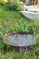 Circular pond surrounded by wildflowers - The Refuge Garden in aid of Help Refugees UK, RHS Malvern Spring Festival 2017 - Design: Sue Jollans, Sponsors: Readyhedge, Everedge, Outchester and Ross Farm Cottages