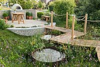 Roped walkway over circular ponds and wildflower meadow, to outdoor pizza oven and seating area - The Refuge Garden in aid of Help Refugees UK, RHS Malvern Spring Festival 2017 - Design: Sue Jollans, Sponsors: Readyhedge, Everedge, Outchester and Ross Farm Cottages