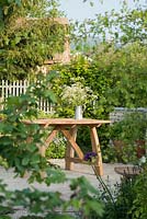 Cow Parsley in a jug on a wooden table - The Refuge Garden in aid of Help Refugees UK, RHS Malvern Spring Festival 2017 - Design: Sue Jollans, Sponsors: Readyhedge, Everedge, Outchester and Ross Farm Cottages