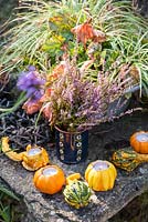 Autumnal still life on a stone table featuring decorative pumpkin candle holders  and a blue vase with heather - October, France