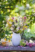 Jug of wildflowers. Leucanthemum, Salvia, Galium verum, yellow ox eye, Silene vulgaris - Bladder campion, Alchemilla, red valerian, daisies.
