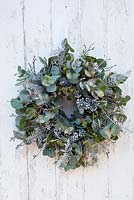 Christmas wreath with eucalyptus, juniper berries and sprayed white fern leaves, ivy berries and twigs