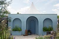 Mediterranean style garden with paved area and blue arched wall - Viking Cruises World of Discovery Garden, RHS Hampton Court Palace Flower Show 2017