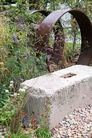 Self-seeded perennials surround rusted steel and concrete structures, including Buddleja davidii, Foeniculum vulgare and Pilosella aurantiaca -  Brownfield Metamorphosis, RHS Hampton Court Palace Flower Show 2017
