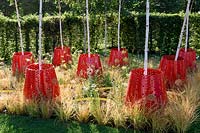 Kinetica garden. Young Betula trees planted in moving Kinetic planters placed amongst circular shallow pools surrounded with Anemanthele lessoniana Design: John Warland. Sponsors: Paneltech Systems. RHS Hampton Court Palace Flower Show 2017