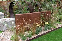 Brownfield- Metamorposis. Planting in gravel bed with the backing of large steel structure, Achillea and grasses, Design: Martyn Wilson Sponsors: St. Modwen. RHS Hampton Court Palace Flower Show 2017
