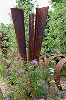 Brownfield - Metamorposis. Rusted steel structures in gravel garden. Design: Martyn Wilson Sponsors: St. Modwen. RHS Hampton Court Palace Flower Show 2017