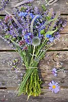 Buunch of blue and purple summer flowers the table. Cornflower, Echinops ritro, chives, origanum, veronicastrum, elephant garlic, lavandula, Verbena bonariensis.