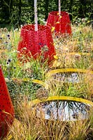 Hampton Court Flower Show, 2017. Kinetica Garden. Red planters with Betula jacquemontii above small circular ponds.