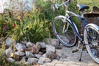 Hampton Court Flower Show, 2017. The Power to Make a Difference Garden. Bicycle in garden
