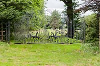 Ornamental metal gate by Richard Bent, Farleigh House, Farleigh Wallop, Hampshire. June. Designer Georgina Langton. 