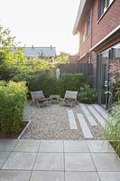 Small suburban garden. Terrace with concrete tiles