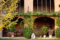 Seating area and containers under arches. Govone. Garden project by Anna Regge. Piemonte, Italy.