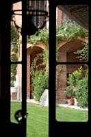 Garden viewed through french doors. Govone. Garden project by Anna Regge. Piemonte, Italy.