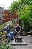 Garden owner and designer Steven Wells, relaxing with his father Ken in front of the fire pit.