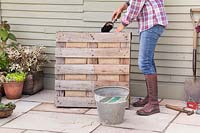 Woman filling in pallet with additional compost