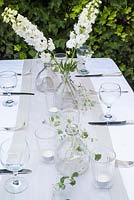 Table arrangement with simple white and grey theme - white delphiniums and grey foliage