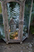 Minature winter wonderland inside vintage lantern with ferns