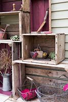 Vinatge crate storage with wire baskets, garden tools and Allium seed heads