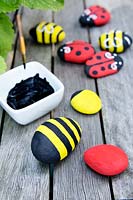 Garden craft making painted Bumble bees and Ladybirds with stones. Paint black stripes on to the body of the Bumble bee