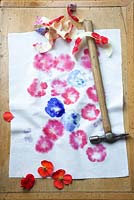 Printing onto fabric with fresh flowers. Gently hammer round and round on to the flowers so they leave an imprint on to the fabric and when finished remove the masking tape and any remnants of the flowers