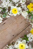 Border of decorative spring flowers on wooden board