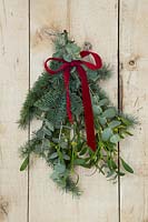 Door decoration with Abies nobilis, Eucalyptus and Mistletoe and red ribbon