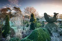 Yew and Box topiary in Charlotte and Donald Molesworth's garden, Kent, UK.