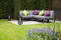 Corner sofa with colourful cushions in contemporary suburban garden