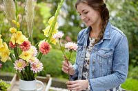 Woman creating Gladiolus and Dahlia bouquet