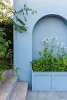 Mediterranean style garden with paved area and blue arched wall and Nicotiana sylvestris in a planter - Viking Cruises World of Discovery Garden, RHS Hampton Court Palace Flower Show 2017 - Designer: Paul Hervey-Brookes