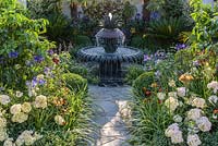 Crazy paving path leading to decorative water fountain with jasmine, salvias, agapanthus, lemons and cycads, box, ivies and hydrangeas - Great Gardens of the USA The Charleston Garden, RHS Hampton Court Palace Flower Show 2017 - Designer: Sadie May Stowell