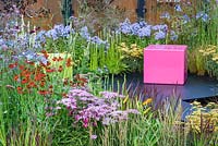 Decorative pink cubed seating, and colourful borders with Achillea 'Pretty Belinda', Helenium 'Moerheim Beauty', Penstemon 'Garnet', Agapanthus 'Blue Triumphator', Verbena bonariensis and Imperata cylindrica 'Rubra' - Colour Box garden - RHS Hampton Court Palace Flower Show 2017 - Designers: Charlie Bloom and Simon Webster.