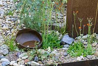 Rusted metal bowl in gravel garden - Brownfield Metamorphosis. RHS Hampton Court Palace Flower Show 2017 - Designer: Martyn Wilson. Sponsor: St. Modwen Properties PLC