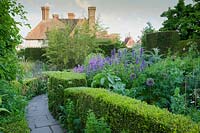 The Orchard Garden in May with Lunaria annua, Cynara, Alliums, and Agastache. Great Dixter, Sussex