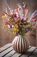 Bouquet of autumn flowers including Persicaria - red bistort 'Firedance', Perovskia 'Blue Spire', Hydrangea paniculata, Anethum in vase 