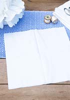Making a paper pom pom from napkins. Open up the 3 napkins and lay them on top of each other