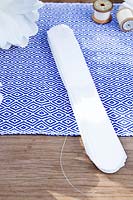 Making a paper pom pom from napkins. Trim the corner of the fastened napkin strip in to a round scalloped shape