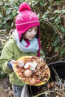 Girl throwing vegetable peelings into the compost
