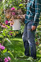 Gardener holding a bucket of garden waste