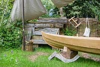 The IBTC Lowestoft: Broadland Boatbuilder's Garden - Early Marsh Orchids next to replica of  900-year-old oak boat  discovered on the Norfolk Broads. RHS Chelsea Flower Show 2017