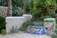 The Viking Cruises Garden of Inspiration - Mediterranean style planting with palms, succulents, Salvia, fruiting orange tree and mosaic covered wall inspired by Gaudi - RHS Chelsea Flower Show 2017 