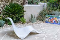 The Viking Cruises Garden of Inspiration - Contemporary white curved lounger among Mediterranean style planting and mosaic covered wall inspired by Gaudi - RHS Chelsea Flower Show 2017 