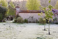 A Lutyens bench on a frosty lawn on an April morning at Heale House, Middle Woodford, Wiltshire