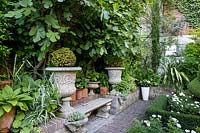 Bench and topiary balls in urns - Crowmarsh House, Kent