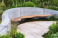 Planting of geums, Anthriscus, Alchemilla mollis and grasses in front of curving concrete and wooden bench, with box and foxgloves  - Digitalis purpurea behind -  'The Jo Whiley Scent Garden' RHS Chelsea Flower Show 2017 - Designers: Tamara Bridge and Kate Savill - Sponsor: RHS