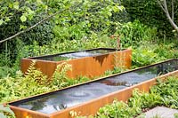 Water bouncing caused by speakers playing music  underground. Rusted corten steel tanks with ferns surrounding - BBC Radio 2 Feel Good Gardens - The Zoe Ball Listening Garden, RHS Chelsea Flower Show 2017 - Designer: James Alexander-Sinclair  - Sponsor: RHS