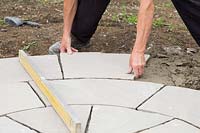 Man laying slabs in centre of circular patio
